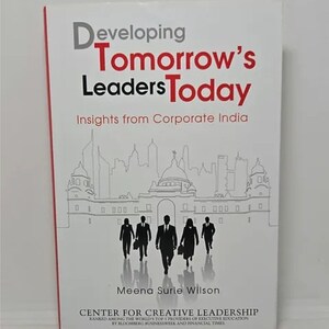 May include: Book cover with a white background and black and white illustration of a city skyline with five silhouettes of people walking in suits. The title of the book is "Developing Tomorrow's Leaders Today" with the subtitle "Insights from Corporate India". The author's name is Meena Surie Wilson. The book is published by the Center for Creative Leadership, which is ranked among the world's top 5 providers of executive education by Bloomberg Businessweek and Financial Times.