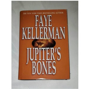 May include: A book cover with an orange background. The title "Jupiter's Bones" is in white text. The author's name "Faye Kellerman" is in white text above the title. The text "The New York Times Bestselling Author" is in white text at the top of the cover.