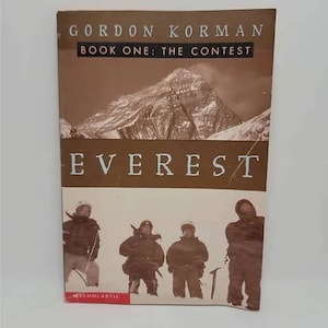 May include: A book cover with a brown background featuring a mountain range and four people standing in the snow. The title of the book is "EVEREST" and the author is "GORDON KORMAN". The book is part of a series called "Book One: The Contest".