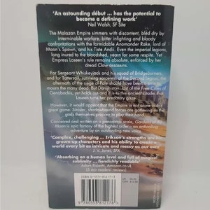 K&ouml;nnte beinhalten: Ein Buchcover mit dunkelblauem Hintergrund und einem wei&szlig;en und goldenen Design. Der Titel des Buches lautet "Gardens of the Moon" und der Autor ist Steven Erikson. Das Buch wird als "epische Fantasy vom h&ouml;chsten Niveau" und "ein fesselndes Abenteuer von einer herausragenden neuen Stimme" beschrieben.