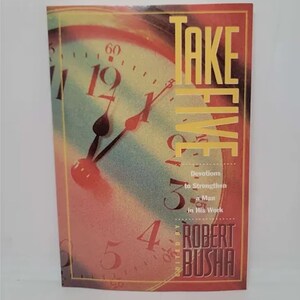 May include: A book titled "Take Five: Devotions to Strengthen a Man in His Work" edited by Robert Busha. The cover features a clock face with Roman numerals and a red background.