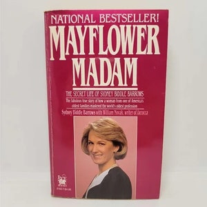 May include: A pink book cover with the title "Mayflower Madam" in white text. The book is a true story about a woman from one of America's oldest families who mastered the world's oldest profession. The book cover features a photo of a woman with blonde hair and a white blouse.