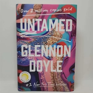 May include: A book cover with a colorful abstract design and the title "Untamed" by Glennon Doyle. The cover also features the text "Over 2 million copies sold" and "#1 New York Times bestseller".