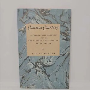 May include: A book titled "Common Courtesy" with a blue marbled cover. The book's subtitle is "In Which Miss Manners Solves The Problem That Baffled Mr. Jefferson." The author is Judith Martin.