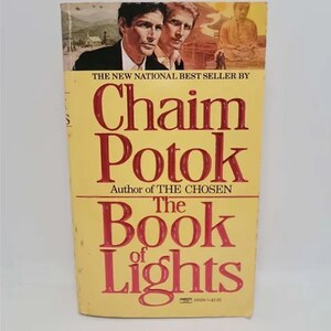 May include: The Book of Lights by Chaim Potok, author of The Chosen. A yellow paperback book cover with a photo of two men and a Buddha statue.