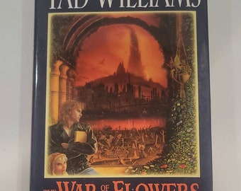 The War of the Flowers Hardcover – May 6, 2003 by Tad Williams This standalone portal fantasy transports unsuccessful rockstar Theo Vil