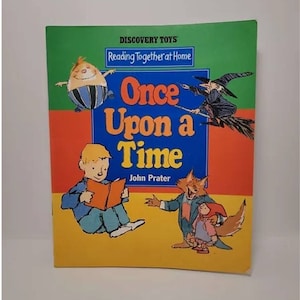 May include: A colorful book cover with the title "Once Upon a Time" and the author "John Prater". The cover features illustrations of a witch, a boy reading a book, a fox, and a girl in a red hood.