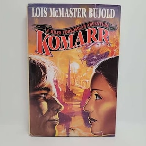 May include: A paperback book cover with a colorful illustration of two people looking at each other. The book title is "Komarr" and the author is Lois McMaster Bujold. The book is a Miles Vorkosigan adventure.