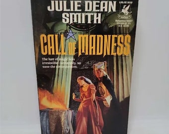May include: A paperback book cover with a dark background and a fiery scene. The title is "Call of Madness" by Julie Dean Smith. The book is a Del Rey Book.