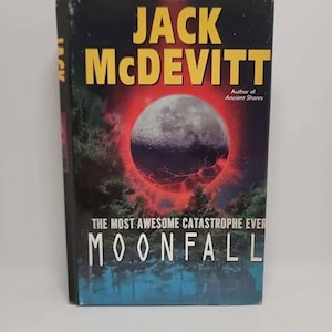 May include: A book cover with a black background and a red and black image of the moon falling from the sky. The title of the book is "Moonfall: The Most Awesome Catastrophe Ever" by Jack McDevitt. The author is also listed as the author of "Ancient Shores".