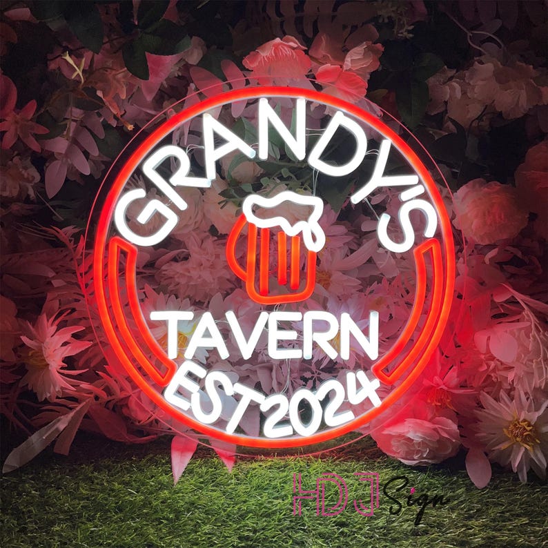 May include: A white neon sign with a red outline in the shape of a circle. The sign says "Grandy's Tavern Est 2024" and features a beer mug with foam on top.