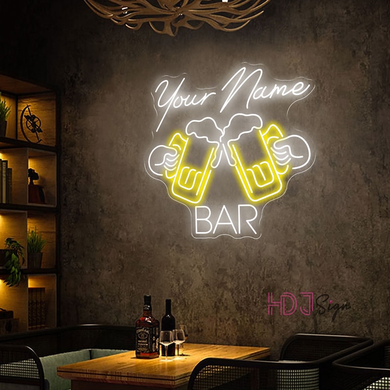 Op de afbeelding: Neon-bord met de tekst "Your Name Bar" in wit met twee gele bierglazen die klinken.