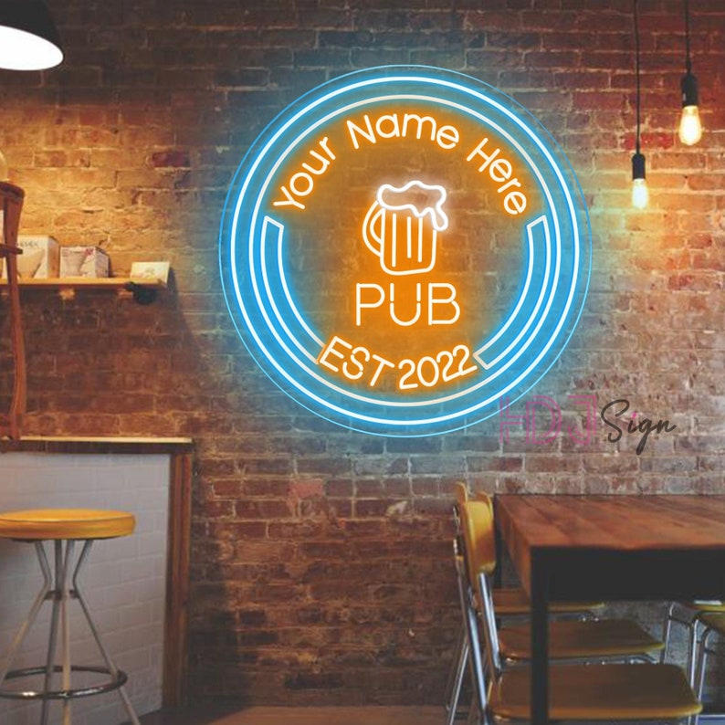 May include: Neon sign with a blue and orange circular design. The sign says "Your Name Here Pub Est 2022" and features a beer mug icon.