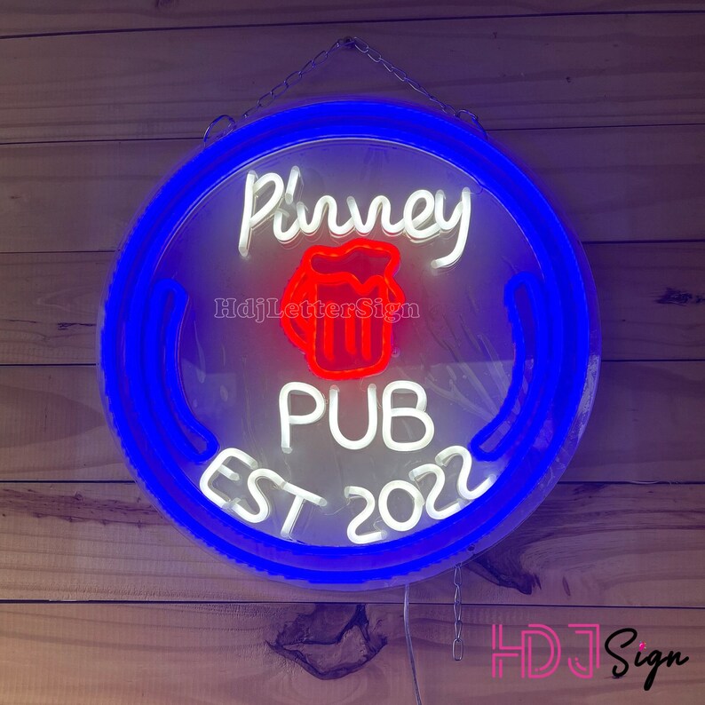 May include: A white neon sign with a blue border, reading "P'urney Pub Est 2022". A red and white beer mug icon is in the centre of the sign.