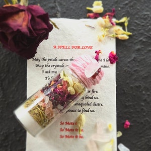May include: A glass bottle filled with dried flowers, herbs, and crystals. The bottle is labelled "A Spell for Love" and includes the text "May the petals caress the, May the crystals, I ask my, To, ne I lo, mine, ir fire, y bind us, aneqauled desire, Aness to find us, So Mote 1, So Mote it, So Mote it be."