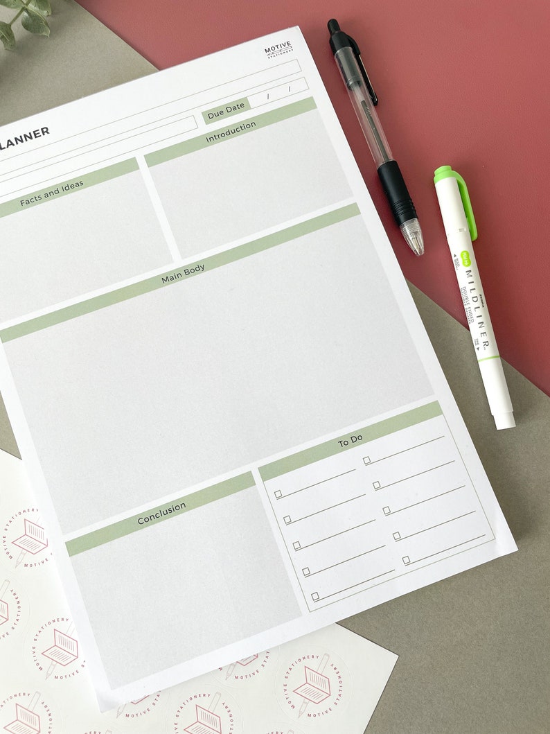 May include: A white planner with a green header that says "Planner". The planner is divided into sections for facts and ideas, introduction, main body, conclusion, and to do. There is a black pen and a green highlighter on top of the planner.
