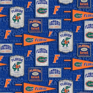 May include: A blue and orange fabric pattern featuring the University of Florida Gators logo, mascot, and text. The pattern includes the words "Florida Gators", "University of Florida", "Gainesville, Florida", and "Established 1853".