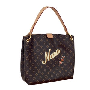 May include: Brown monogrammed handbag with a tan leather handle and gold-tone hardware. The word "Nana" is written in a cursive font, with a butterfly graphic. The bag has a shoulder strap.