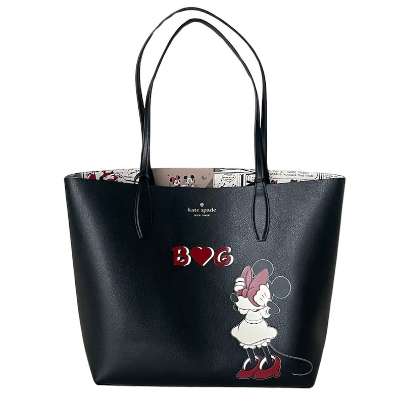 May include: Black tote bag with black handles and a Minnie Mouse graphic. The bag features the text "kate spade new york" and the letters "B♡G". The interior lining has a comic strip design. The Minnie Mouse graphic is in white, red, and black.