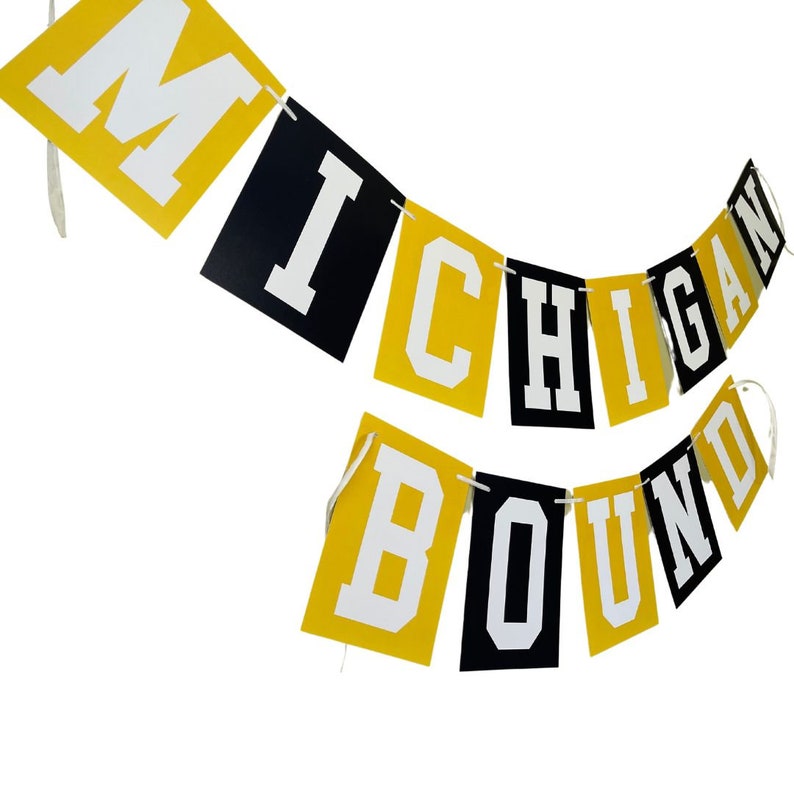 May include: A yellow and black banner with the words "Michigan Bound" in white letters.