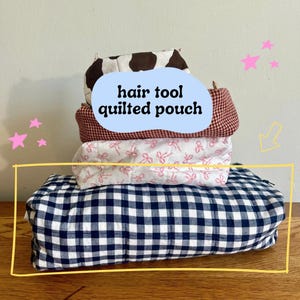 May include: A stack of four quilted pouches in various patterns. The top pouch has a brown and white cow print. The second pouch is red and white checkered. The third pouch is white with pink bows. The bottom pouch is navy and white gingham. Text on the image reads "hair tool quilted pouch."