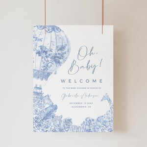 May include: A blue and white baby shower welcome sign with a hot air balloon, animals, and the text "Oh Baby! Welcome to the baby shower in honor of Gabriela Anderson December 18 20XX Alexandria, VA"