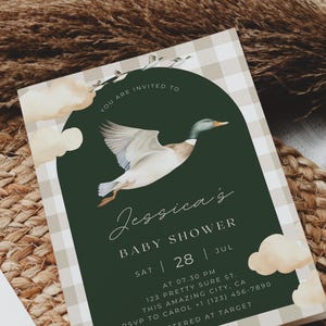 May include: A green and white gingham baby shower invitation with a watercolor illustration of a duck flying through the air. The text reads "You are invited to Jessica's Baby Shower Sat | 28 | Jul AT 07.30 PM 123 Pretty Sure St. This Amazing City, CA RSVP to Carol +1 (123) 456-7890 Registered at Target"