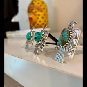 May include: Three silver-toned metal air freshener clips shaped like birds, each featuring an oval turquoise stone set in the center. The bird-shaped ornaments have detailed engraved wing and tail patterns and are attached to black plastic clips.