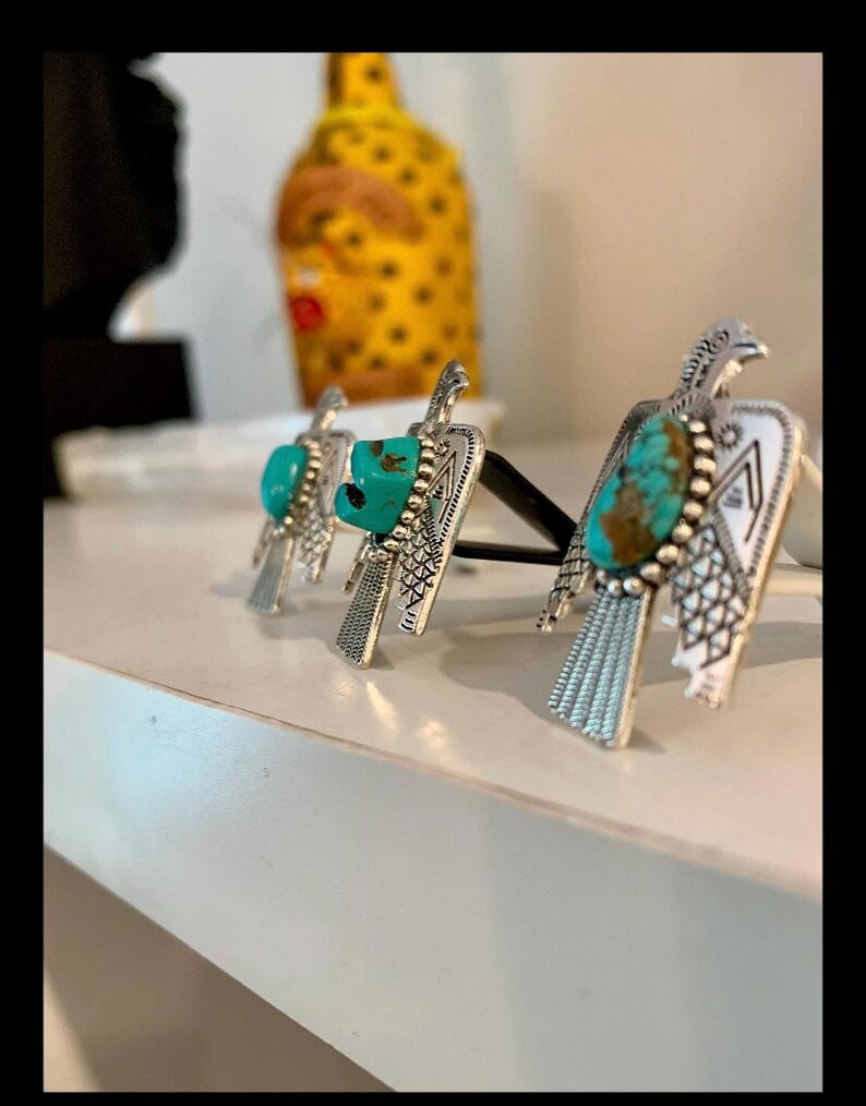 May include: Three silver-toned metal air freshener clips shaped like birds, each featuring an oval turquoise stone set in the center. The bird-shaped ornaments have detailed engraved wing and tail patterns and are attached to black plastic clips.