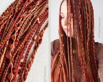 May include: A set of synthetic hair extensions featuring a mix of braids, twists, and loose strands in shades of auburn, copper, and light brown. The hair is adorned with small wooden beads and wrapped accents, with the text 27HairTreasures visible.