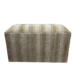 May include: A rectangular ottoman with a striped pattern in shades of beige and gray. The ottoman has a slightly curved top and a tapered base, offering a neutral color palette for various interior styles.