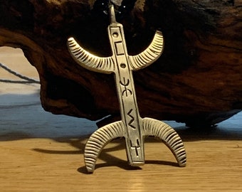 May include: A silver pendant necklace with a stylized symbol and intricate details. The pendant is hanging from a black beaded chain.