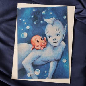 May include: A blue and white mermaid with a pink octopus on her shoulder. The mermaid has a long, flowing tail and a crown of seaweed on her head. The octopus has eight tentacles and is smiling. The background is a blue and green ocean with bubbles.