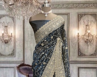 Greyish blue stiff shimmer net saree with glitter work and running blouse piece