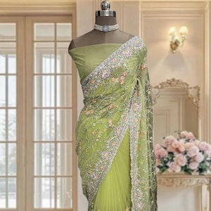 Yellowish green net saree with thread and sequins work and running blouse piece