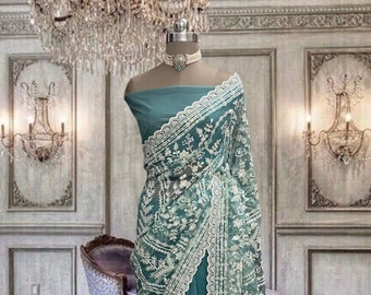 Turquoise blue net saree with thread, stone and sequins work and running blouse piece