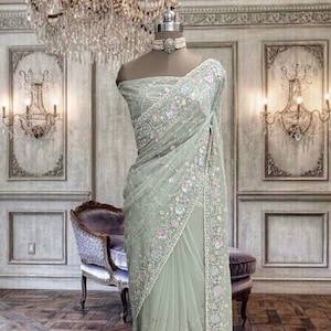 Beautiful pastel green soft organza saree with beads and sequins embroidery and running blouse piece