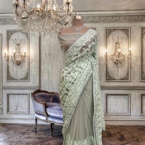 Pastel green thread work net saree with running blouse piece