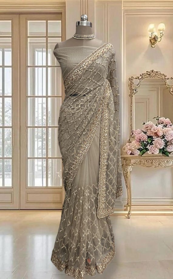 Beige Gold Net Saree with Zari and Sequins Work, Includes A Running Blouse Piece.