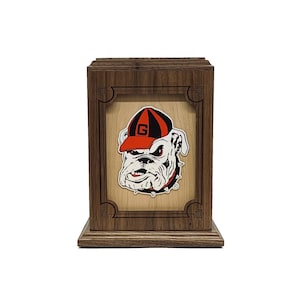 May include: A wooden box with a framed image of a bulldog wearing a red and white baseball cap with a "G" on it. The box is made of dark wood with a light wood frame around the image.