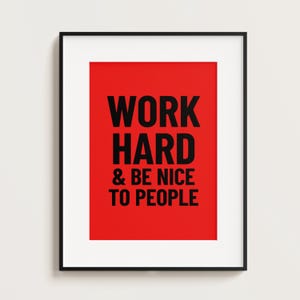 May include: A framed wall art print featuring a vibrant red background with bold black sans-serif text that reads WORK HARD & BE NICE TO PEOPLE. The artwork is enclosed in a thin black frame, creating a clean and high-contrast visual display.