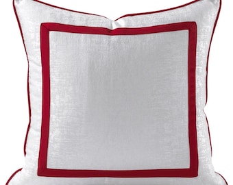 May include: White square throw pillow with a red border.