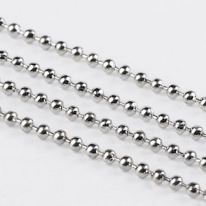 May include: A close-up of a silver ball chain. The chain is made of small, round beads that are linked together.
