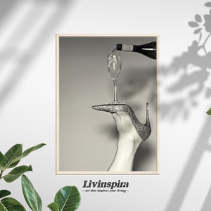 Czarno-białe zdjęcie Eleganckie nalewanie wina do szklanki na błyszczącym szpilkowym obcasie Plakat ścienny | Luksusowa sztuka stylu życia – Oprawiony plakat nr 61