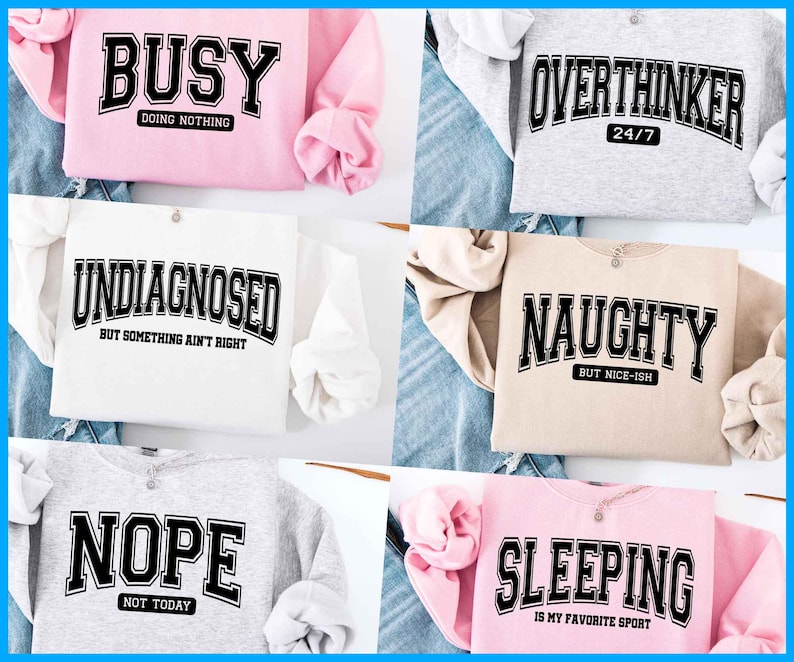 May include: Five different sweatshirts with humorous text printed on the front. The sweatshirts are in various colors, including pink, white, beige, gray, and light pink. The text on the sweatshirts includes "Busy Doing Nothing", "Undiagnosed But Something Ain't Right", "Overthinker 24/7", "Naughty But Nice-ish", "Nope Not Today", and "Sleeping Is My Favorite Sport".
