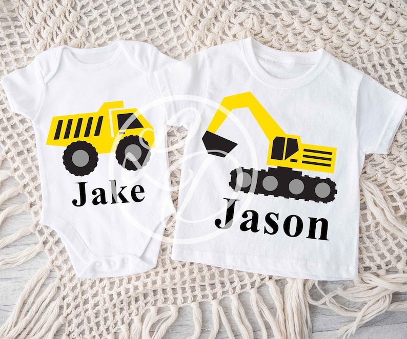 May include: Two white t-shirts with a yellow dump truck and excavator design. The shirts are personalized with the names "Jake" and "Jason".