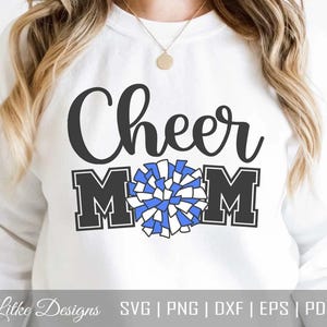 May include: White sweatshirt with the text "Cheer Mom" in black with a blue and white pom-pom graphic.
