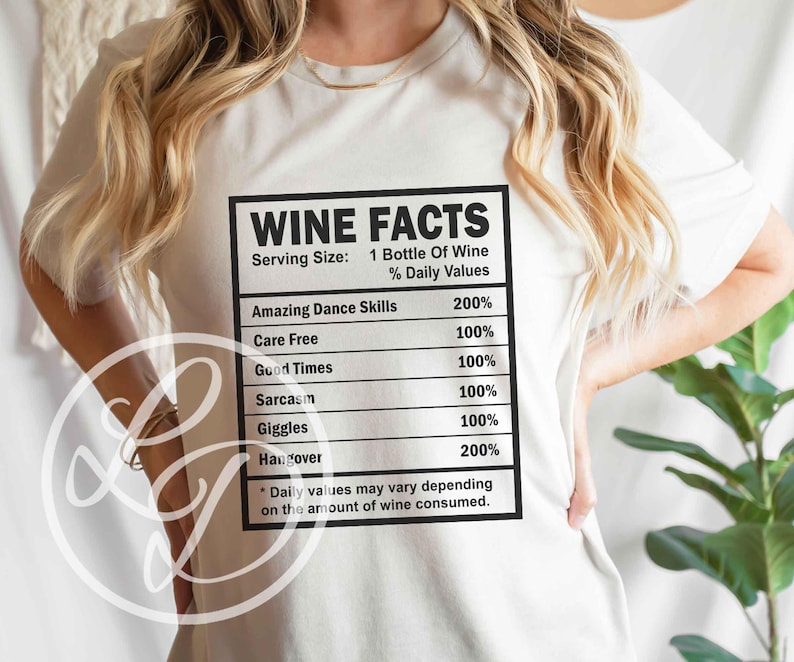 May include: White t-shirt with a black graphic that reads "Wine Facts" and lists the percentage of daily values for things like "Amazing Dance Skills", "Care Free", "Good Times", "Sarcasm", "Giggles", and "Hangover".