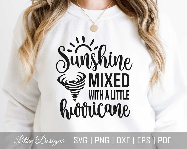 May include: White sweatshirt with black text that reads "Sunshine mixed with a little hurricane". The text is in a cursive font and includes a sun and a tornado graphic.