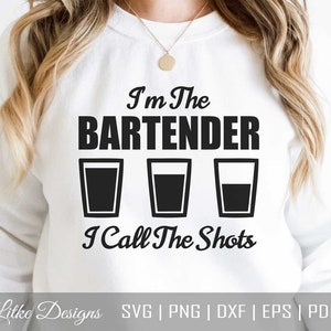 May include: White sweatshirt with black text that reads "I'm The Bartender I Call The Shots" with three black shot glasses underneath the text.